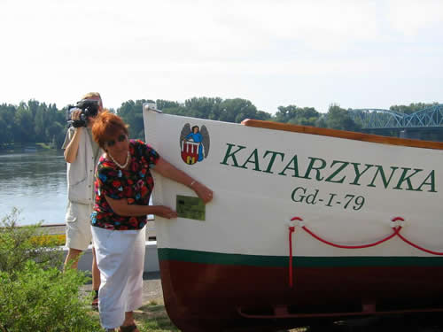 Ewa Potarzyńska, Dyrektor Biura Związku Miast Nadwiślańskich, przymierza pamiątkową tabliczkę z logo ZMN.